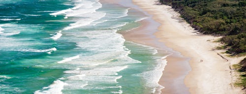 Australia Travel Photography Panoramic Photo of Surfers Heading Out to Surf on a Deserted Tallow Beach at Byron Bay Gold Coast Australia