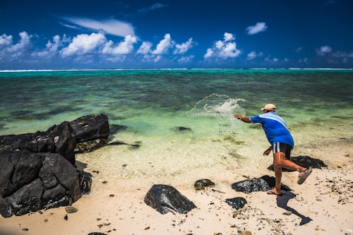 Cook Islands Landscape Travel Photography Fisherman net fishing from a beach in Muri Rarotonga Cook Islands