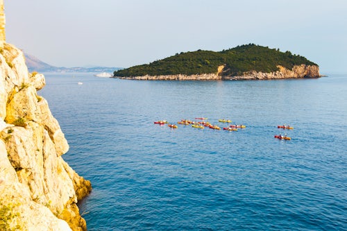 Croatia Travel Photography Sea Kayaking in Dubrovnik tourists kayak past Buza Bar and Lokrum Island Dubrovnik Croatia