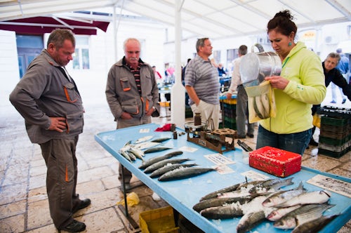 Croatia Travel Photography Split fish market a lady sells fish to two Croatian men Dalmatia Croatia