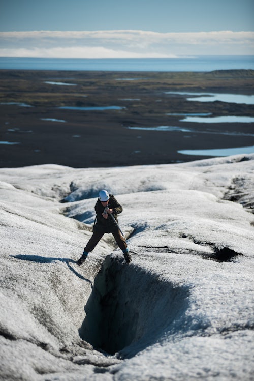 Iceland Travel Photography Old man on adventure holiday taking a photo of a crevasse on Breidamerkurjokull Glacier Vatnajokull Ice Cap Iceland Europe