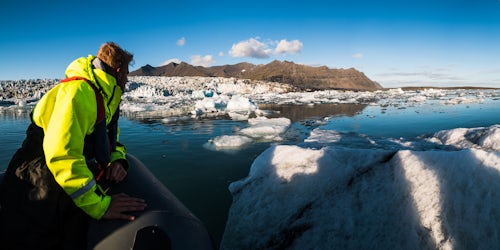 Iceland Travel Photography Tourist on a Zodiac boat tour of Jokulsarlon Glacier Lagoon a glacial lake filled with icebergs in South East Iceland