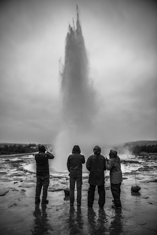 Iceland Travel Photography Tourists watching Strokkur Geyser erupt Geysir The Golden Circle Iceland