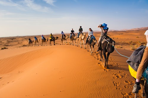 Morocco Travel Photography Tourists on a camel ride in Erg Chebbi Desert Sahara Desert near Merzouga Morocco North Africa Africa