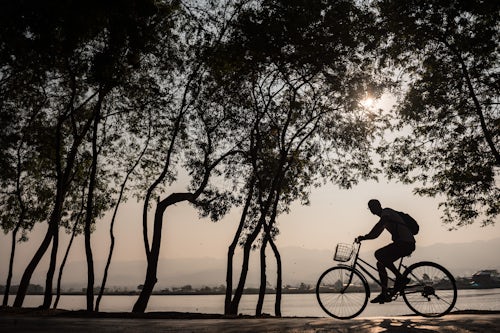 Myanmar Burma Travel Photography Tourist exploring Inle Lake by bicycle at sunset Shan State Myanmar Burma