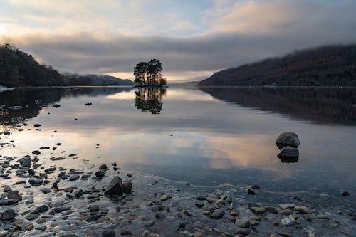 Scotland Landscape Photography Lone trees on an island reflecting in Loch Tay Lake at sunset with dramatic sunset sky reflections Kenmore Perthshire Highlands of Scotland United Kingdom Europe