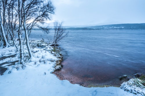 Scotland Landscape Photography Loch Morlich in snow in winter Glenmore Cairngorms National Park Scotland United Kingdom Europe