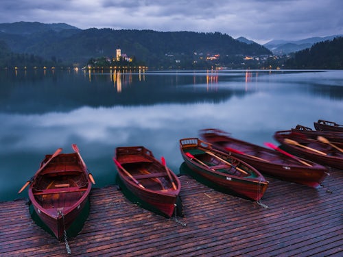 Slovenia Landscape Photography Pletna rowing boats and Lake Bled Island at twilight Bled Gorenjska Slovenia Europe