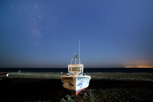 Spain Landscape Photography Boat under stars at night on the beach Cabo de Gata Nijar Natural Park Andalucia Almeria Spain Europe background with copy space