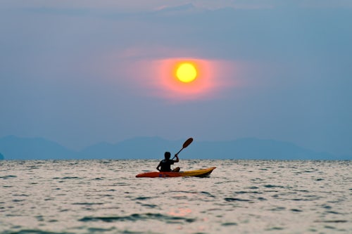 Thailand Travel Photography One Man Kayaking at Sunset on Tropical Ao Phra Nang Beach Railay Rai Leh South Thailand Southeast Asia