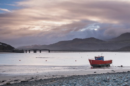 Wales Landscape Photography Old fishing boat and Barmouth Bridge in Barmouth Harbour with Cader Cadair mountains behind part of Snowdonia National Park Gwynedd North Wales Wales United Kingdom Europe